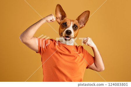 A dog with a brown and white coat, wearing an orange t-shirt, stands against a yellow background with both arms flexed to show off its biceps. The dog's tongue is sticking out A dog with a brown and white coat, wearing an orange t-shirt, stands against a yellow background with both arms flexed to show off its biceps. The dog's tongue is sticking out 124083801