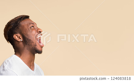 Anger. Aggressive Black Guy Screaming Loudly Standing Over Yellow Background In Studio. Panorama, Copy Space, Side View 124083818