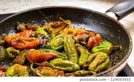 Close-up selective focus shot of fried padron peppers in a cooking pan 124083933