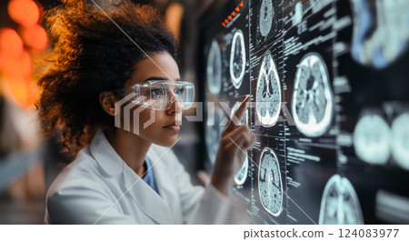 A researcher examines brain scans on a digital screen while wearing protective eyewear in a modern laboratory. 124083977