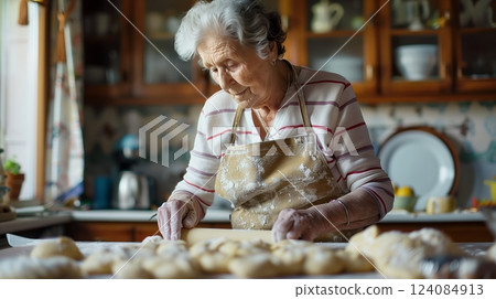 A senior woman rolls dough in her neat kitchen, the state pension giving her peace and financial security. 124084913