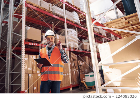 Positive mood. Employee in uniform is working in the storage at daytime 124085026