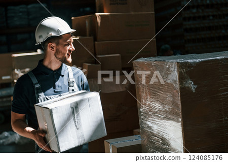 In dark store. Employee in uniform is working in the storage In dark store. Employee in uniform is working in the storage 124085176