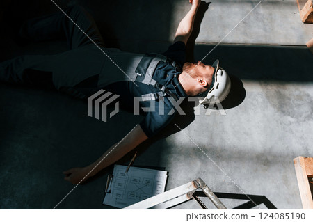 Storage worker fell from the height. Body is on the floor. Terrible accident. Safety first 124085190