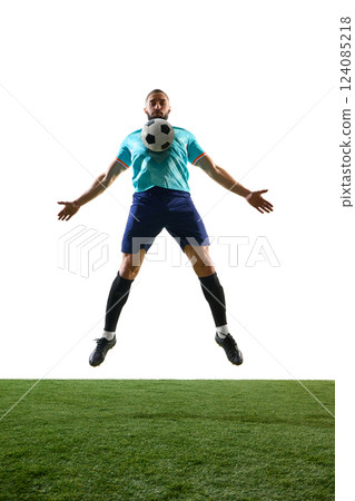 Front view of football player in blue uniform mid-air, chest-controlling ball with arms wide on green field against white background. Front view of football player in blue uniform mid-air, chest-controlling ball with arms wide on green field against white background. 124085218