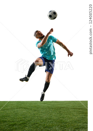 Football player mid-air skillfully heading ball, body control in motion, intense focus on trajectory. Dynamic shot. Football player mid-air skillfully heading ball, body control in motion, intense focus on trajectory. Dynamic shot. 124085220