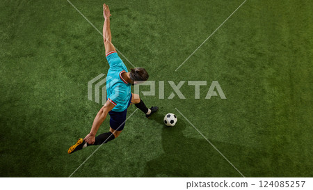 Elevated action shot of football athlete positioning body for decisive play, arms stretched, leg flexed, ready to impact game. Elevated action shot of football athlete positioning body for decisive play, arms stretched, leg flexed, ready to impact game. 124085257