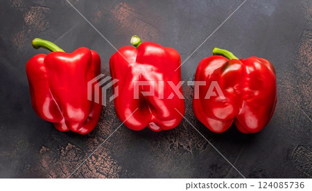 Top view of red peppers on the dark background Top view of red peppers on the dark background 124085736