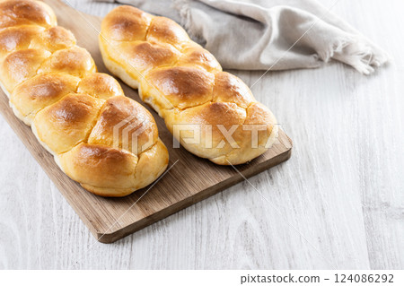 Traditional Easter braided bread. Tsoureki braid on white wooden table 124086292