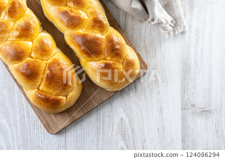 Traditional Easter braided bread. Tsoureki braid on white wooden table Traditional Easter braided bread. Tsoureki braid on white wooden table 124086294