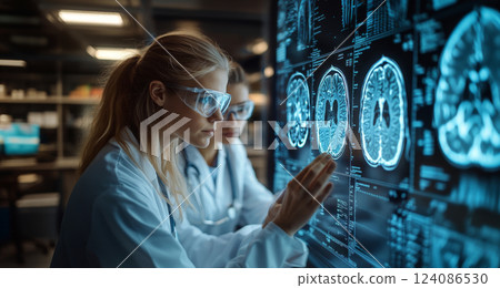 Two researchers examine detailed brain scans on a digital display, engaged in analysis within a high-tech laboratory. 124086530