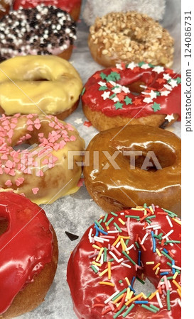 Fresh donuts in the box from the local bakery shop. Mixed freshly baked doughnuts with toppings. 124086731