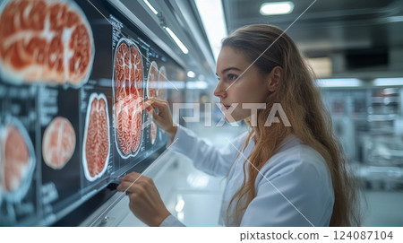 A medical expert studies detailed brain imaging data on a digital display, reflecting intense concentration in a modern lab environment. 124087104