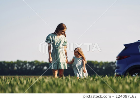 Holding each other by hands. Mother and daughter have fun outdoors on the field at summer Holding each other by hands. Mother and daughter have fun outdoors on the field at summer 124087162