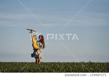 Mother and daughter have fun outdoors on the field at summer 124087171