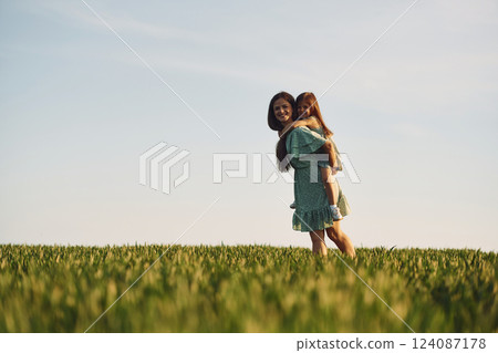 Clear sky. Mother and daughter have fun outdoors on the field at summer Clear sky. Mother and daughter have fun outdoors on the field at summer 124087178