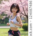 A woman wearing black shorts running in a park with cherry blossoms 124087486