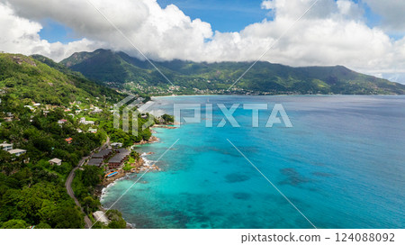 Tropical bay surrounded by lush green mountains and turquoise sea. Seychelles, Mahe. Beau Vallon Beach. 124088092