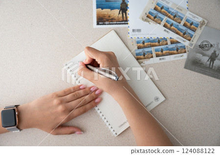 TERNOPIL, UKRAINE - June 28: Postage stamps "Russian warship... done". Woman writing letter 124088122