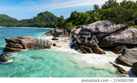 White sandy beach with green vegetation covering the hills. Baie Lazare. Seychelles, Mahe. 124088190