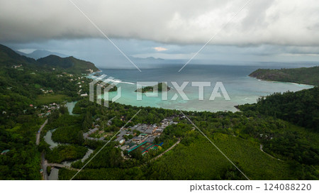 An isolated green island surrounded by the ocean under an overcast sky. Seychelles, Mahe. Port Launay. An isolated green island surrounded by the ocean under an overcast sky. Seychelles, Mahe. Port Launay. 124088220