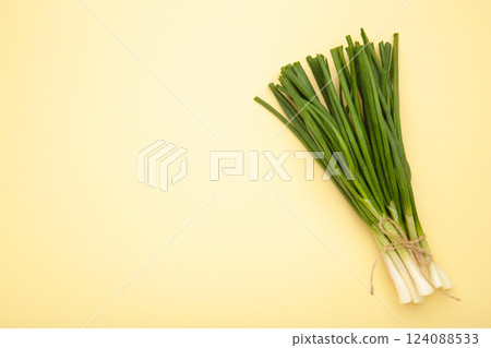 Fresh green onion on beige background. Space for text 124088533