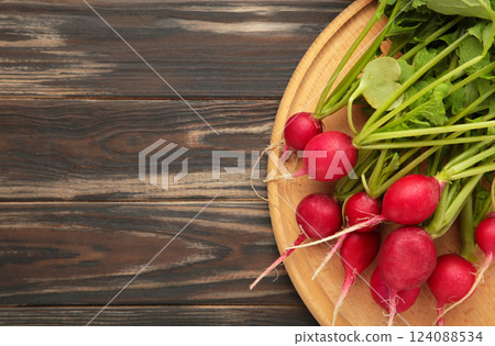 Fresh radishes on brown wooden background. Space for text 124088534