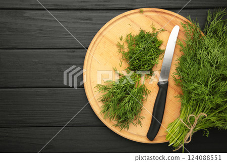 Cut dill on cutting board on black background Cut dill on cutting board on black background 124088551