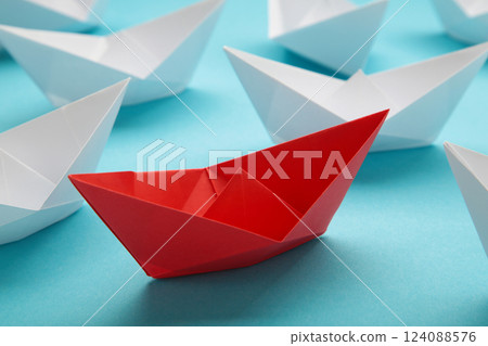 Leadership concept. Red leader paper ship leading among white on blue background. 124088576