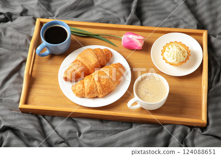 Breakfast in bed with coffee, croissants and tulip on tray 124088651