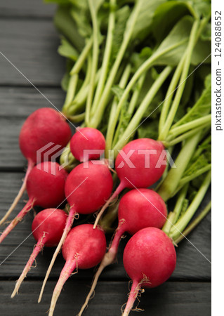 Fresh radishes on grey wooden background. Vertical photo 124088652