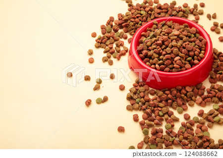 Pet food in red bowl on beige background. 124088662