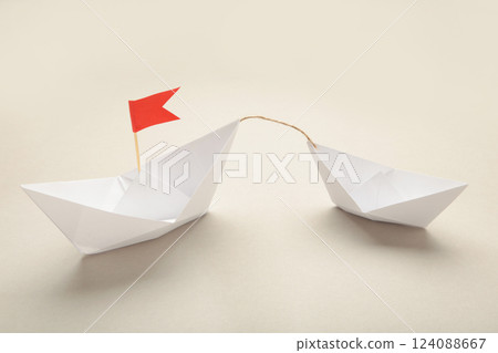 Paper boats - Tugboat or Remorker pulling a big boat on grey background. Little helper concept 124088667