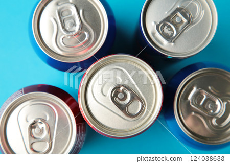 Aluminum drink or beverage cans with pull ring on blue background. 124088688