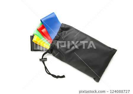 A set of colorful latex rubber bands for fitness and a black cover for them isolated on white background. Sports concept. A set of colorful latex rubber bands for fitness and a black cover for them isolated on white background. Sports concept. 124088727