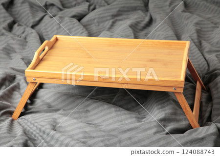 Empty wooden tray on a grey bed. Empty wooden tray on a grey bed. 124088743