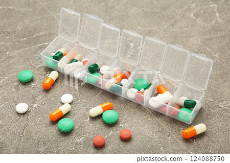 Daily pill box with medications and nutritional supplements on grey background. 124088750