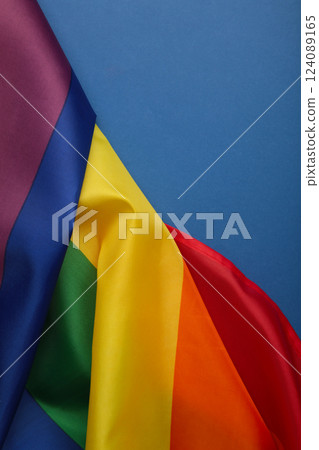 The rainbow flag (LGBT) on blue background. Vertical photo. The rainbow flag (LGBT) on blue background. Vertical photo. 124089165