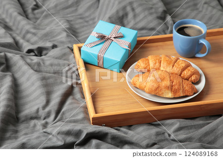 Father's day concept with gift and breakfast on tray. Breakfast for dad with croissant and coffee. 124089168