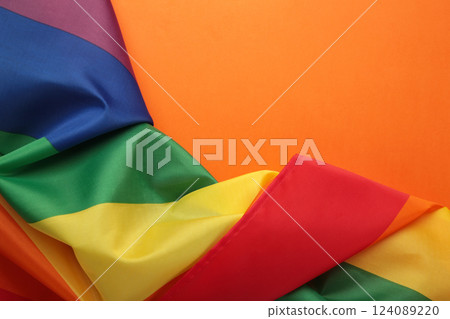 The rainbow flag (LGBT) on orange background. Top view. Space for text 124089220