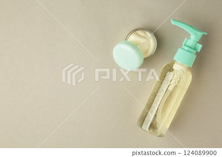 Facial cosmetic cream in transparent open jar, beauty product on grey background. Space for text 124089900