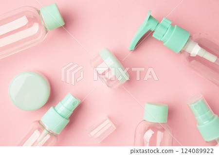 Empty travel cosmetic bottles on pink background. Minimalist bodycare beauty products for vacation or journey. Top view. Copyspace. 124089922