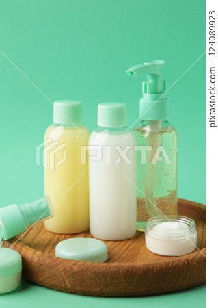 Travel cosmetic bottles with tray on mint background. Minimalist bodycare beauty products for vacation or journey. Top view. Copyspace. 124089923