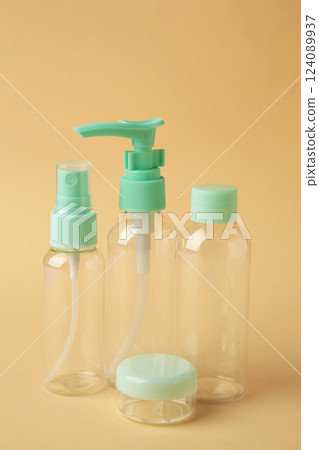 Empty travel cosmetic bottles on beige background. Minimalist bodycare beauty products for vacation or journey. Top view. Copyspace. 124089937