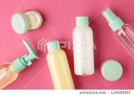 Travel cosmetic bottles on pink background. Minimalist bodycare beauty products for vacation or journey. Top view. Copyspace. Travel cosmetic bottles on pink background. Minimalist bodycare beauty products for vacation or journey. Top view. Copyspace. 124089997