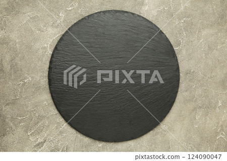 Black slate stone on grey concrete background. 124090047