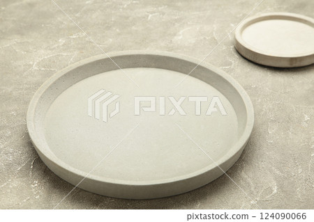 Empty ceramic round plate on grey concrete background with clipping path 124090066