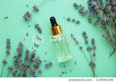Flat lay composition with lavender flowers and lavender oil on mint background Flat lay composition with lavender flowers and lavender oil on mint background 124090196