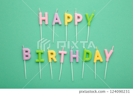 Colorful candles in letters saying Happy Birthday on mint background Colorful candles in letters saying Happy Birthday on mint background 124090231