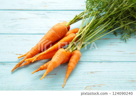 Bunch of baby carrots on blue wooden background Bunch of baby carrots on blue wooden background 124090240